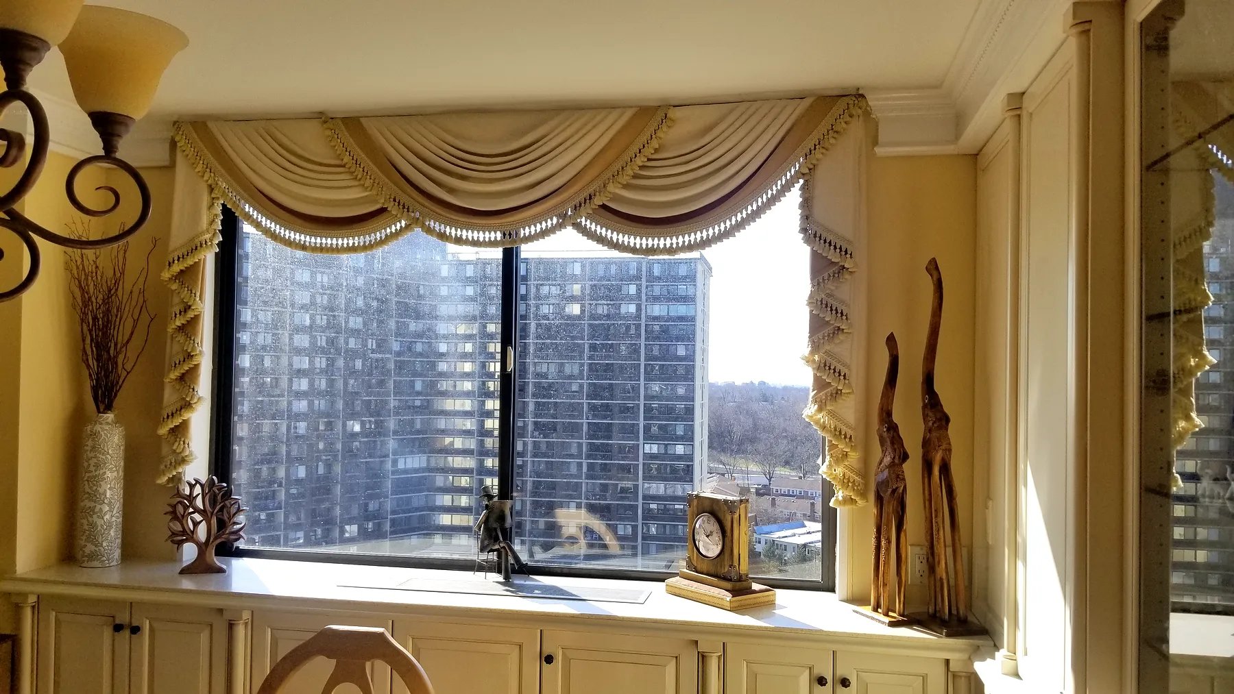 Traditional swag and jabot valance with beaded trim over an apartment window