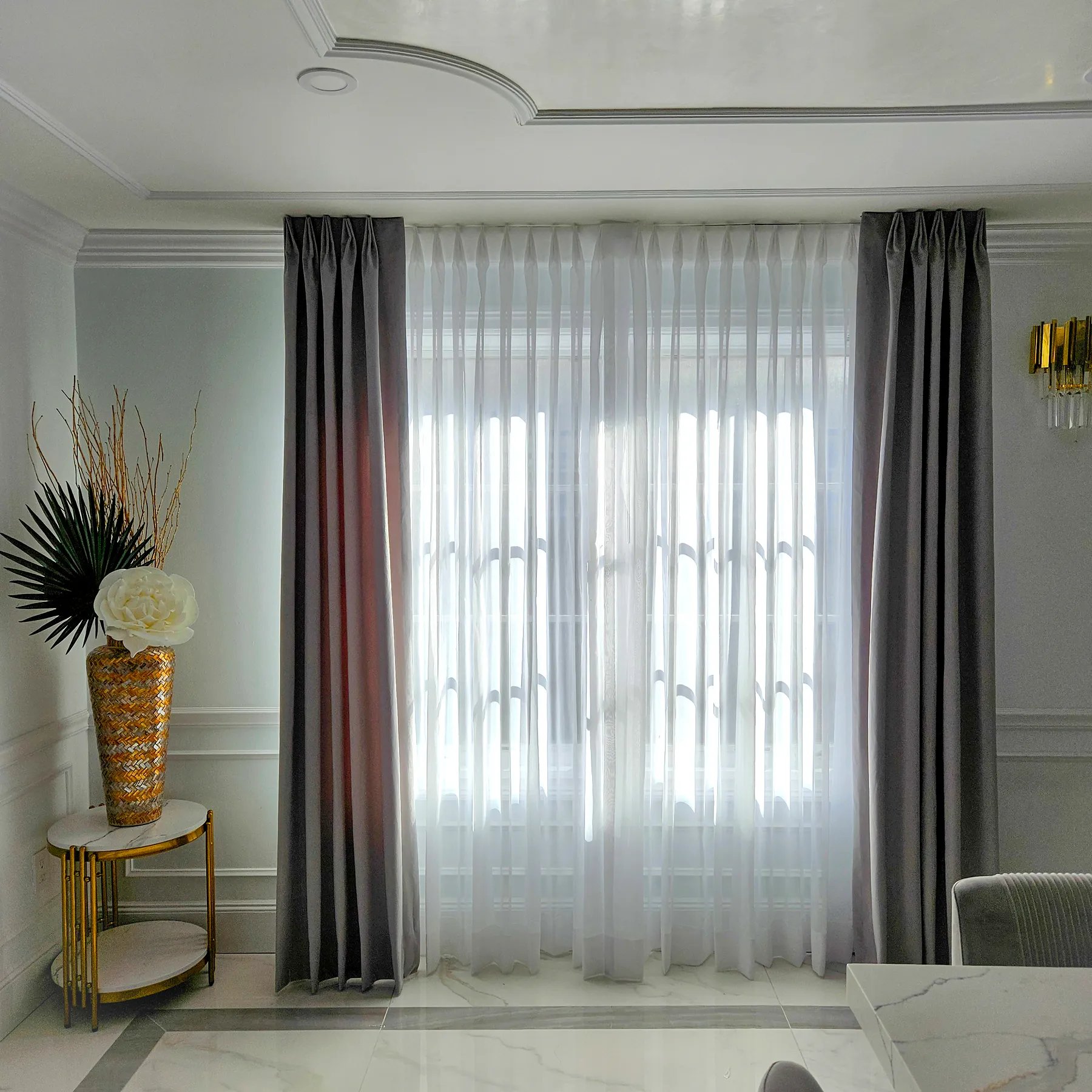 Double-rod drapery with sheer pinch pleat panels behind textured side drapes